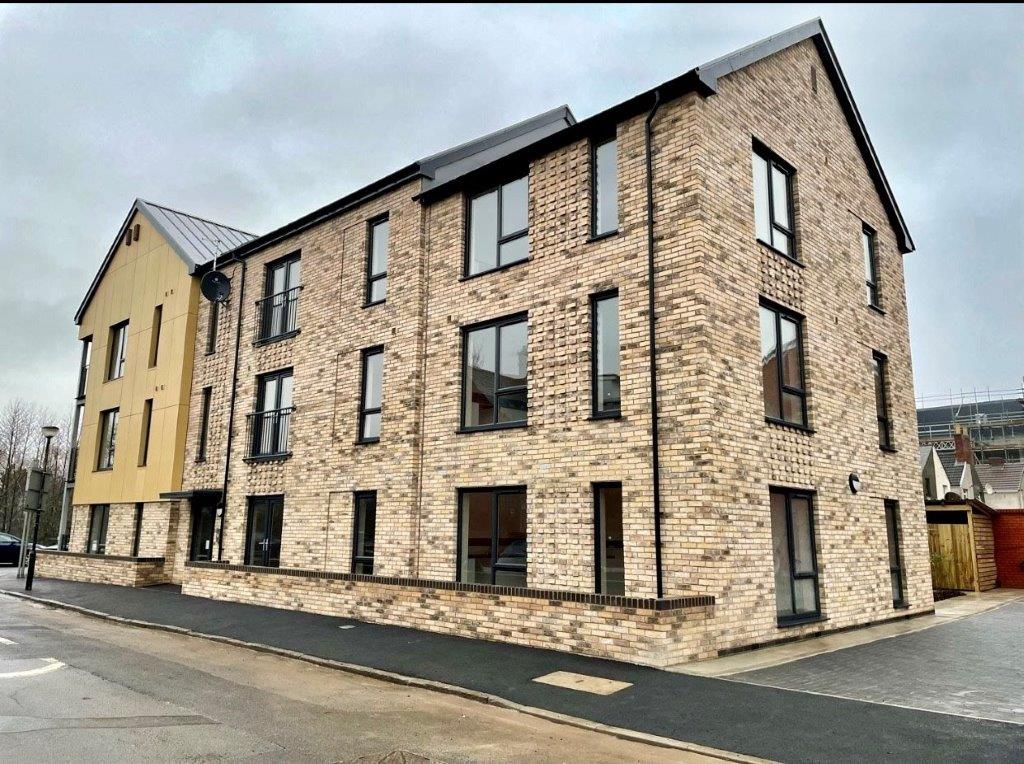 An image of apartments with yellow and beige brick rendering